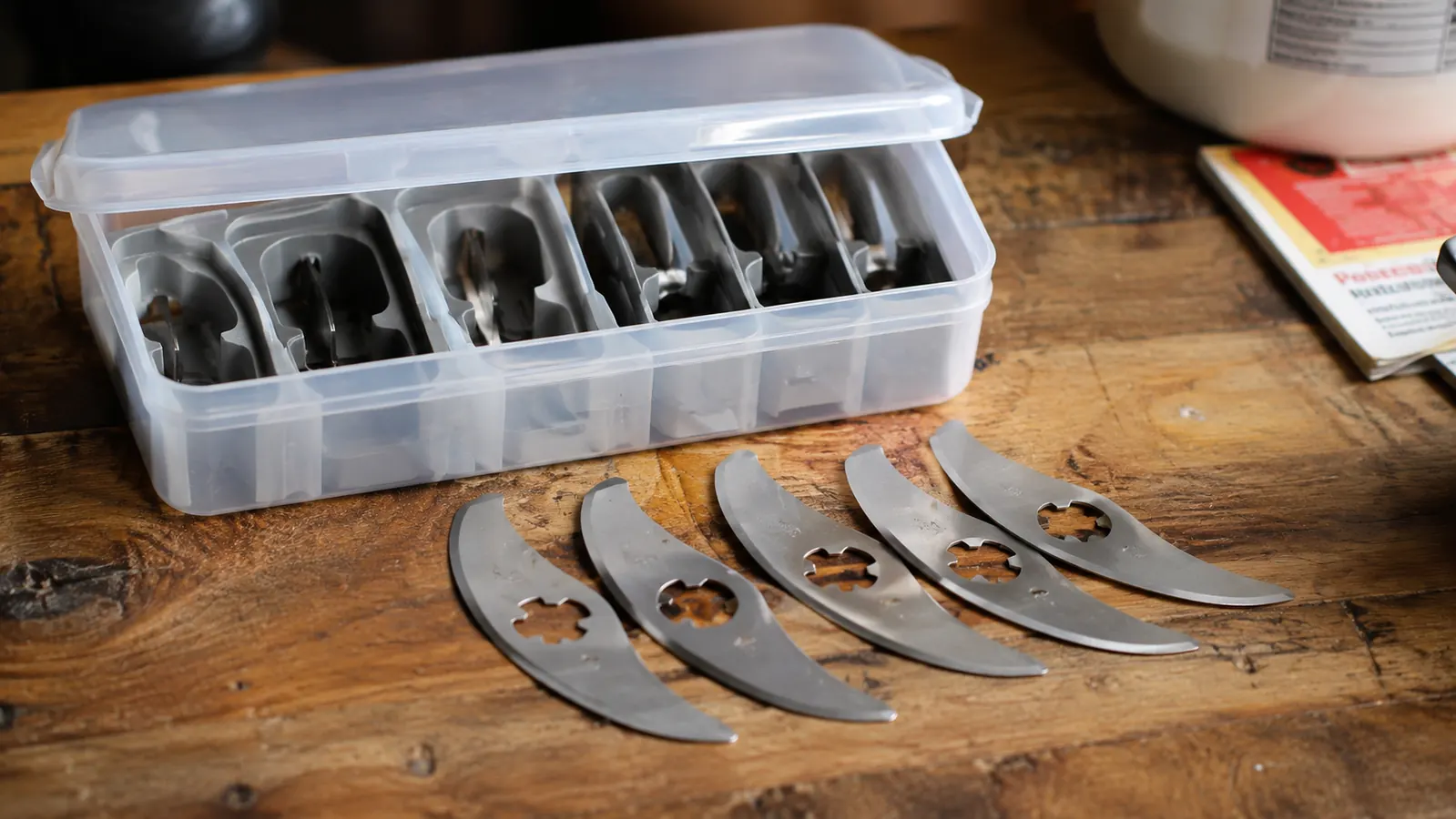 Fullstar chopper blade inserts spread out on a counter next to their plastic storage case with the lid slightly ajar